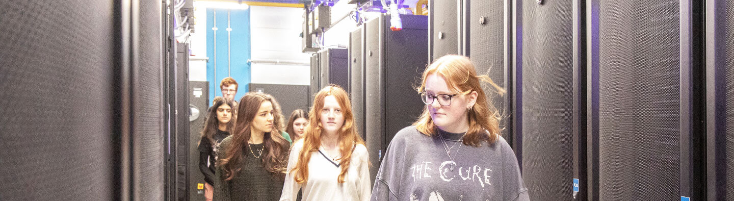 A group of young people are walking through a bioinformatics lab